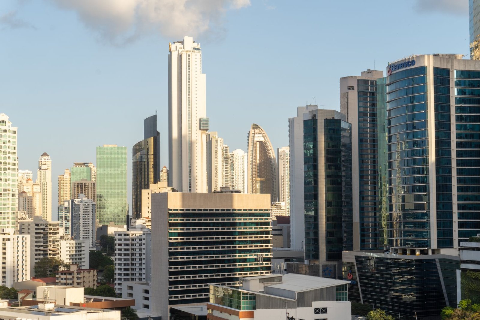 Sunlit view of Panama City's modern skyscrapers under clear blue sky.